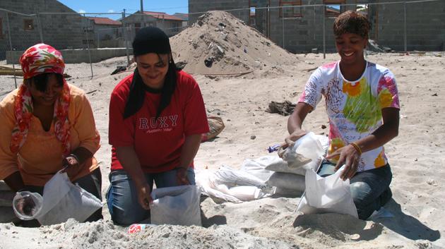 Ženy z místní chudinské komunity naplňují pytle s pískem. (foto: Nadya Glawe / © Design Indaba)